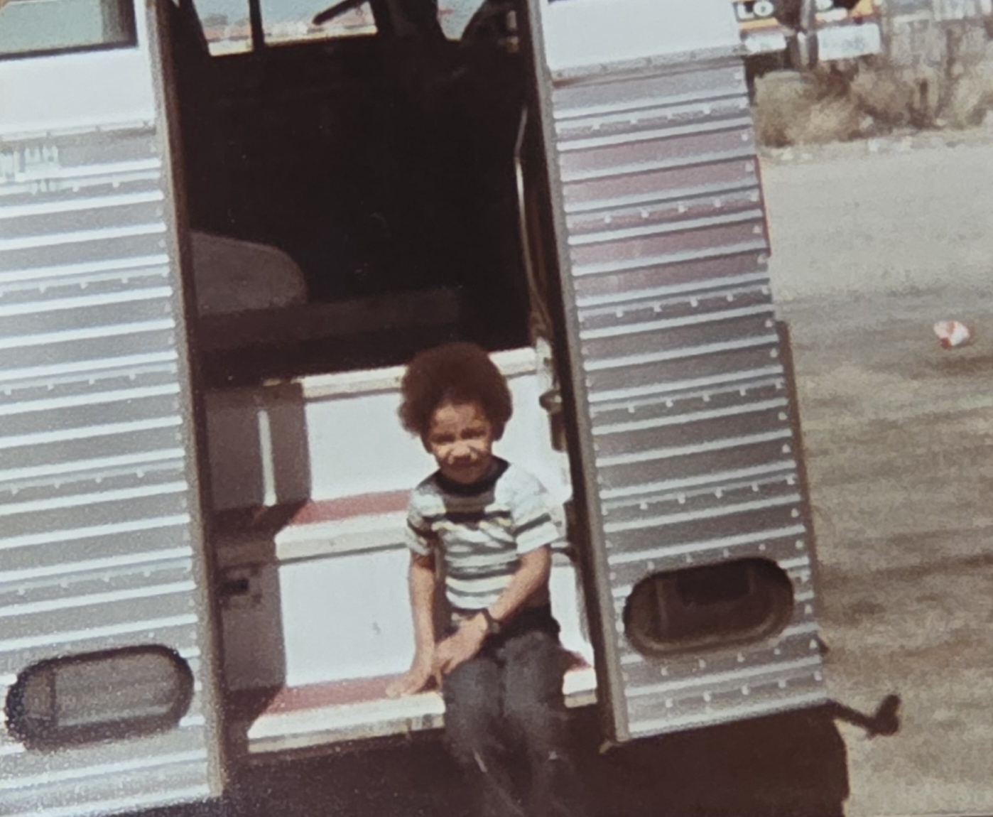 Lawyer A. Twillie II as a young child standing in a truck doorway during his childhood in Section 8 housing